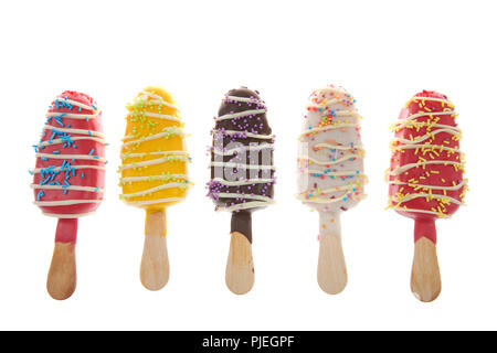 Fila di più caramelle colorate spogliato ghiaccioli cake pops con spruzza sulla cima isolata su sfondo bianco. Divertimento piatti per le feste per bambini Foto Stock