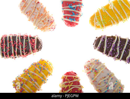 Close up su più caramelle colorate spogliato ghiaccioli cake pops con spruzza sulla cima isolata su sfondo bianco. Divertimento piatti per le feste per bambini Foto Stock