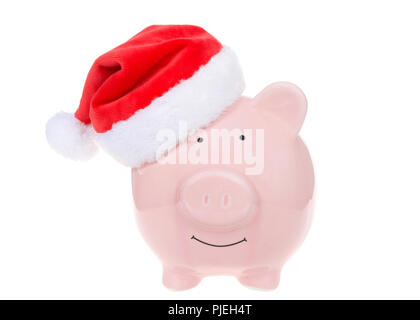 Rosa salvadanaio indossando un cappello da Babbo Natale sorridente visualizzatore rivolto isolato su bianco. Foto Stock