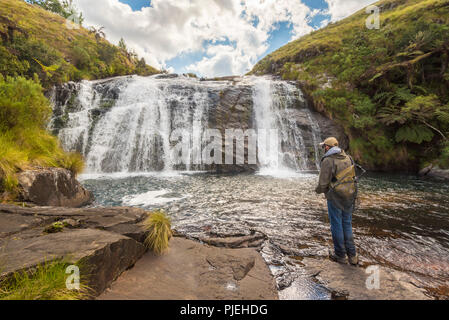 Un pescatore di mosca pesca alle cascate di Temburatedza nel Parco Nazionale Nyanga dello Zimbabwe. Foto Stock