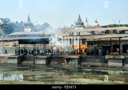 Kathmandu, Nepal - Aprile 15, 2016: la cerimonia di cremazione lungo il sacro fiume Bagmati in Bhasmeshvar Ghat al tempio di Pashupatinath a Kathmandu. - La Foto Stock