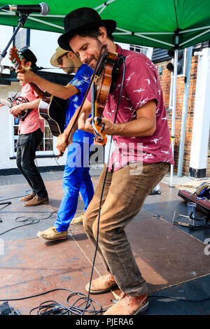 La Orange Circus Band, celtico/bluegrass musica folk di eseguire sul piccolo palcoscenico a sandwich e Folk Festival Ale. Fiddle player in primo piano. Foto Stock