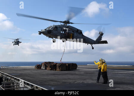 5 settembre 2018 - oceano Atlantico - OCEANO ATLANTICO (sett. 5, 2018) marinai dirigere un MH-60S Sea Hawk elicottero assegnato al Dragon cacciatrici di elicottero di mare squadrone di combattimento (HSC) 11 sul ponte di volo dell'Nimitz-class portaerei USS Harry Truman (CVN 75) durante un rifornimento in mare con il combattimento veloce nave appoggio USNS Arctic (T-AOE-8), non raffigurato. Harry Truman è in conduzione il supporto delle operazioni in Atlantico. (U.S. Foto di Marina di Massa Specialista comunicazione marinaio Maxwell Higgins/RILASCIATO) 180905-N-MQ631-0271 US Navy via globallookpress.com (credito Immagine: © noi N Foto Stock