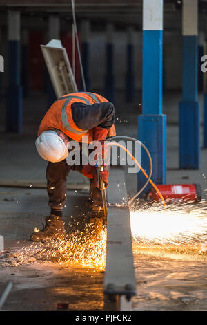 Sito di costruzione lavoratore il taglio di un fascio con una torcia di acetilene Foto Stock