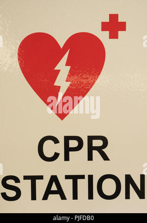 Una stazione di RCP di firmare con un cuore, scosse elettriche e la croce rossa progettazione di rosso su bianco. Foto Stock