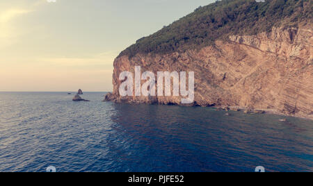 Vista Aeriel punto di ripide scogliere a picco sul mare il sollevamento dal mare. Buljarica, Montenegro. Foto Stock