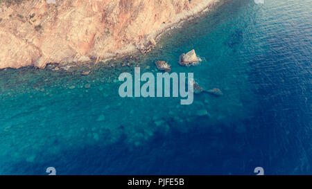 Vista Aeriel punto di ripide scogliere a picco sul mare il sollevamento dal mare. Buljarica, Montenegro. Foto Stock