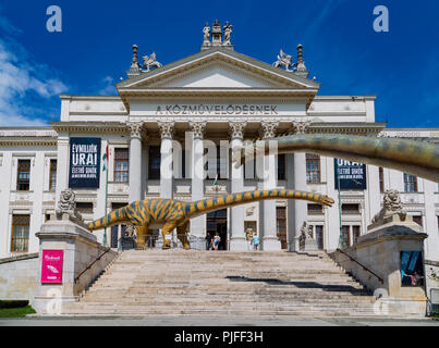 Estate in vista della Mora Ferenc Museum di Szeged. I modelli dei dinosauri di fronte all'entrata dell'edificio neoclassico. Foto Stock