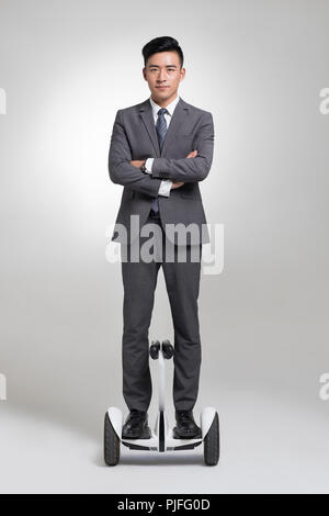Fiducioso giovane imprenditore segway equitazione Foto Stock