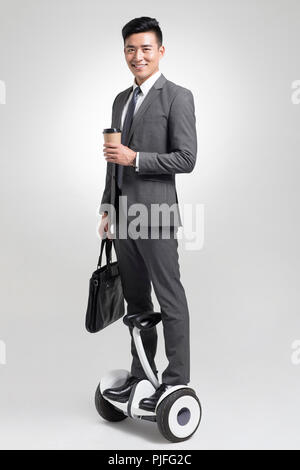 Fiducioso giovane imprenditore segway equitazione Foto Stock