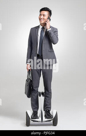 Fiducioso giovane imprenditore segway equitazione Foto Stock