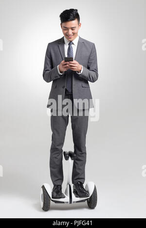 Fiducioso giovane imprenditore segway equitazione Foto Stock