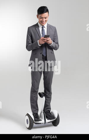 Fiducioso giovane imprenditore segway equitazione Foto Stock
