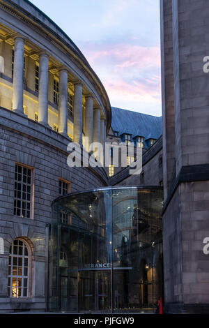 Manchester, Inghilterra, Regno Unito - 1 Luglio 2018: il sole tramonta dietro l'ingresso moderno a Manchester la peste Central Library e Municipio di buil di estensione Foto Stock