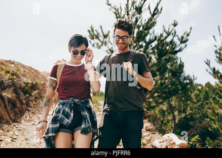 Escursionismo coppia in una località di campagna. L uomo e la donna trekking attraverso una foresta di indossare zaini. Foto Stock