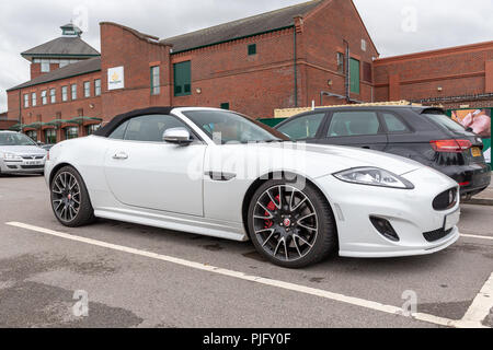 White Jaguar XK "R" in un supermercato parcheggio auto Foto Stock