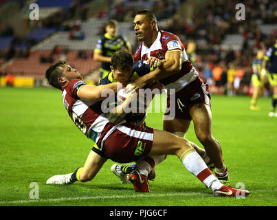 Il Wigan Warriors' Joe legno verde (sinistra) e William Isa (destra) affrontare Wakefield Trinità di Scott Grix durante il Betfred Super League Super 8's corrispondono al DW Stadium, Wigan. Foto Stock