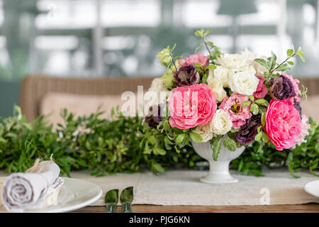 Ordinatamente intrecciati in un tubo sala da pranzo igienico decorate con un rametto di pistacchio. Banchetti per matrimoni o cene di gala. Il tavolo e sedie per gli ospiti, Servita con posateria e stoviglie. party sulla terrazza Foto Stock