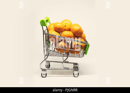 Metallo carrello riempito con le clementine su sfondo bianco. comprare la frutta al supermercato. market basket Foto Stock