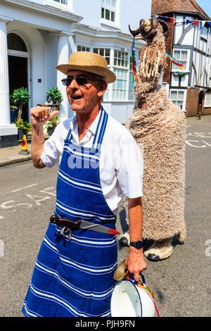 Il Upcross Mummers eseguire un gioco mummer nella città medievale di sandwich. Senior uomo vestito da macellaio tradizionale, dietro, uomo vestito come ram. Foto Stock