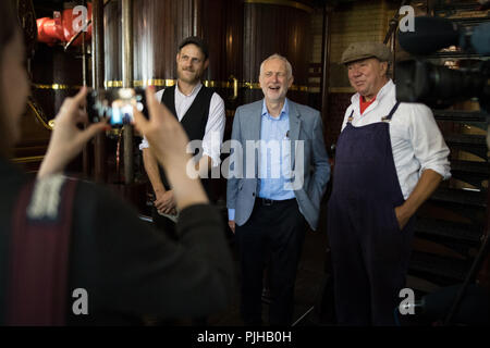 Leader laburista Jeremy Corbyn in posa per una foto con stazione di pompa di volontari come egli è mostrato intorno Abbey Pumping Station in Leicester del Museo Nazionale della Scienza e della tecnologia, Leicester come egli annuncia il partito laburista di piani per prendere il settore idrico in proprietà pubblica. Foto Stock