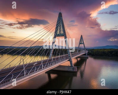 Budapest, Ungheria - Ponte Megyeri oltre il Fiume Danubio al tramonto con belle nuvole drammatico e cielo Foto Stock