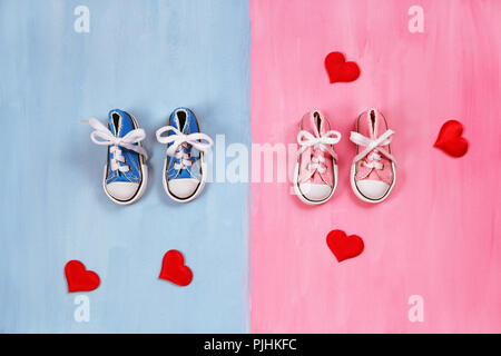 Baby sneakers in rosa e sfondo blu Foto Stock