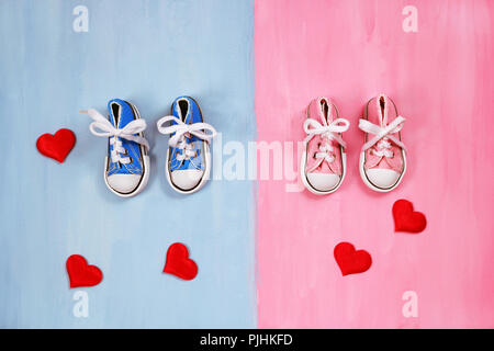 Baby sneakers in rosa e sfondo blu Foto Stock