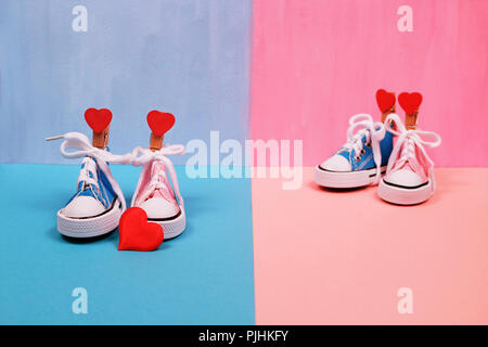 Baby sneakers in rosa e sfondo blu Foto Stock