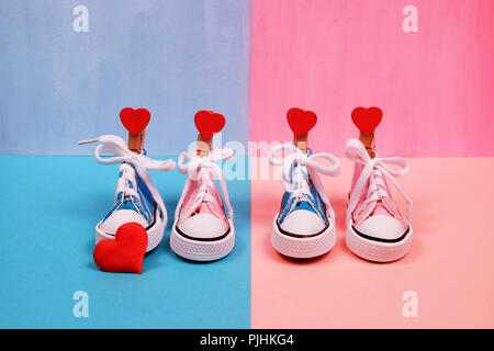 Baby sneakers in rosa e sfondo blu Foto Stock