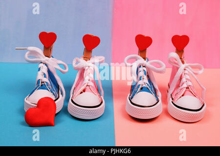 Baby sneakers in rosa e sfondo blu Foto Stock