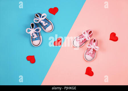 Baby sneakers in rosa e sfondo blu Foto Stock