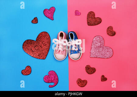 Baby sneakers in rosa e sfondo blu Foto Stock