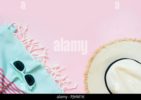 Spiaggia di paglia cappello e occhiali da sole su vigorosi rosa con spazio per il testo. Abito femminile per la spiaggia. Concetto di estate. Foto Stock