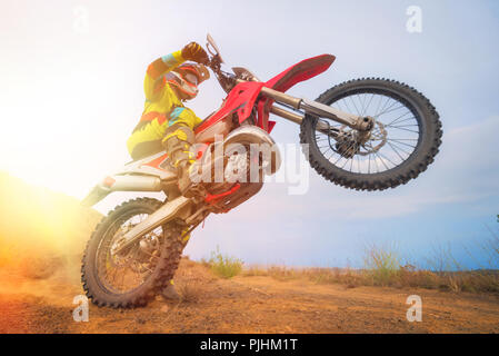 Il pilota di Motocross facendo un'impennata Foto Stock