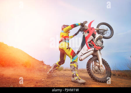 Il pilota di Motocross facendo un'impennata Foto Stock