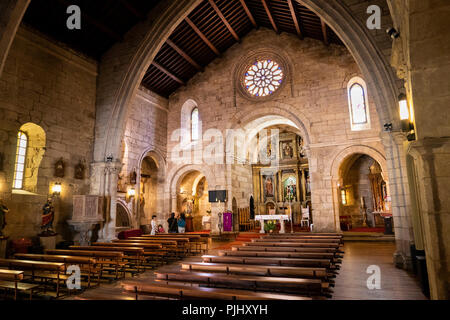 Spagna Galizia, A Coruña, città vecchia, Iglesia de Santiago, interni ai visitatori al di sotto dei arco in pietra sopra altare Foto Stock