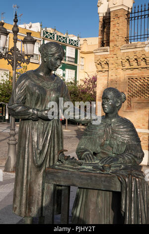 Spagna, Cadiz, scultura in bronzo di donne che fanno i sigari al di fuori di waterfront ex fabbrica di tabacco Foto Stock