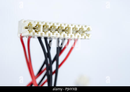 Vecchi cavi per dispositivi elettrici su un tavolo bianco. I connettori elettrici degli elettrodomestici. Sfondo bianco. Foto Stock