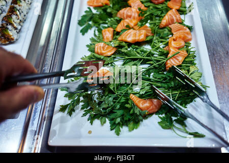 In prossimità di una raccolta a mano un pezzo di sushi Foto Stock