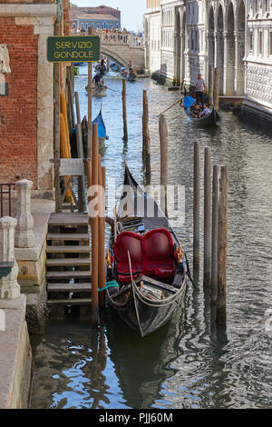 Venezia, Italia - 14 agosto 2017: Vuoto gondola ormeggiate e gondole con cittadini e turisti in una soleggiata giornata estiva in Italia Foto Stock