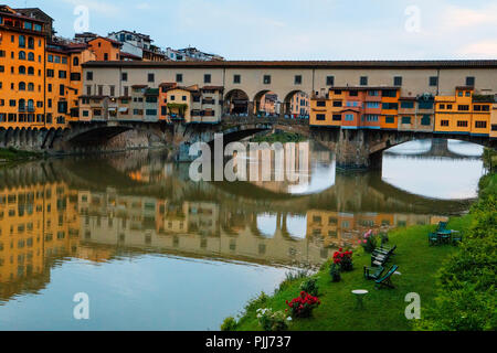 Ponte Vechio il più famoso ponte e le attrazioni turistiche di Firenze si riflette nel fiume Arno ancora acque con architettura lungo il fiume Foto Stock