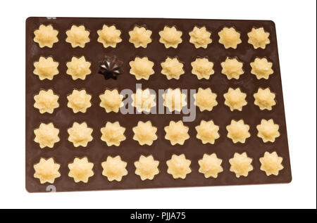 Cottura in silicone forma piena di pasta frolla. Preparazione di dolci tortini di cocco. Impasto crudo. Tradizionali di Natale o Capodanno biscotti a forma di fiore. Foto Stock