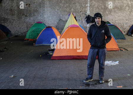 Patrasso, Achaea, Grecia. 29 Mar, 2018. Un rifugiato visto che pongono accanto alla tenda in un campo di fortuna in un ex lumberyard.i migranti e i rifugiati di trovare rifugio in un campo di fortuna che essi hanno fatto a un ex lumberyard accanto al porto di Patrasso. Il porto della città è diventata un importante gateway per i migranti e i rifugiati che cercano di viaggiare in Italia e da lì in altri paesi in Europa. I migranti cercano di raggiungere il porto e nascondere i carrelli in attesa di essere inviati in Italia con il traghetto. Credito: Menelaos Michalatos SOPA/images/ZUMA filo/Alamy Live News Foto Stock