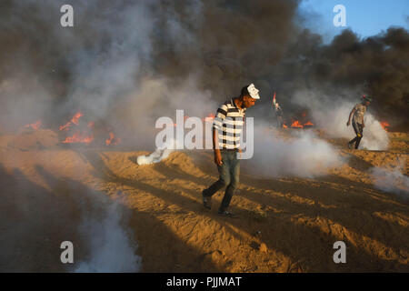 La striscia di Gaza, la Palestina. 7 Sep, 2018. Un uomo palestinese visto a piedi dal gas lacrimogeni incendio fumo da parte delle forze israeliane durante gli scontri.Gli scontri tra le forze israeliane e palestinesi durante una manifestazione di protesta contro la decisione del Presidente Trump al riconoscimento di Gerusalemme come capitale di Israele. La protesta è stata intitolata: ritorno nonostante il tuo naso Trump. Credito: Ahmad Hasaballah SOPA/images/ZUMA filo/Alamy Live News Foto Stock