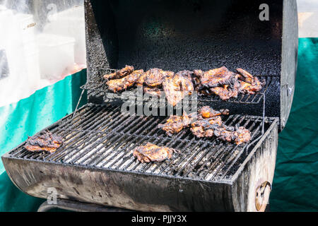 Pollo Jerk cottura su un barbecue a Londra Sud streetfood stallo. Foto Stock