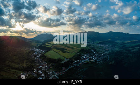 Drone immagine. vista aerea del territorio rurale montano in Slovacchia, villaggi di Zuberec hanno e Habovka da sopra. tramonto spettacolare sopra la montagna con le nuvole Foto Stock