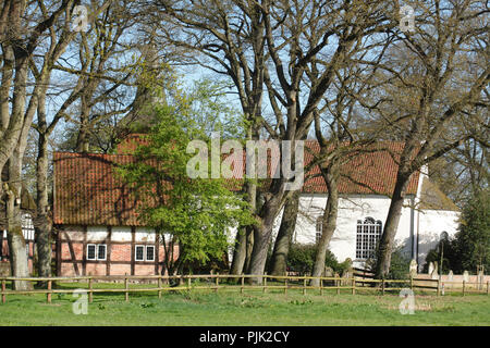 Casa in legno e muratura con Liebfrauenkirche in primavera, Fischerhude, Bassa Sassonia, Germania, Europa Foto Stock