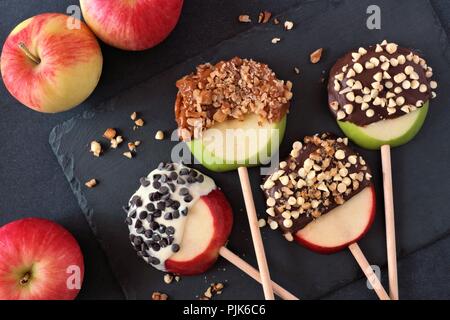 Cioccolato e caramello mele anabbaglianti tornate al di sopra di scena al buio su un sfondo di ardesia Foto Stock