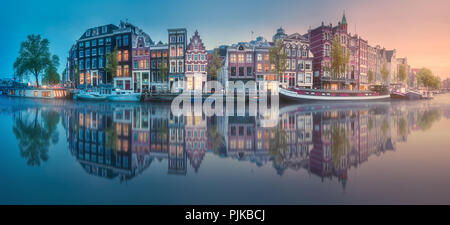 Fiume Amstel, canali e sunrise sulla bellissima città di Amsterdam. Paesi Bassi. Foto Stock